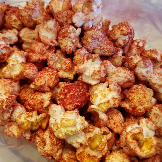 Palomitas cubiertas de chile en polvo rojo dentro de una bolsa transparente.